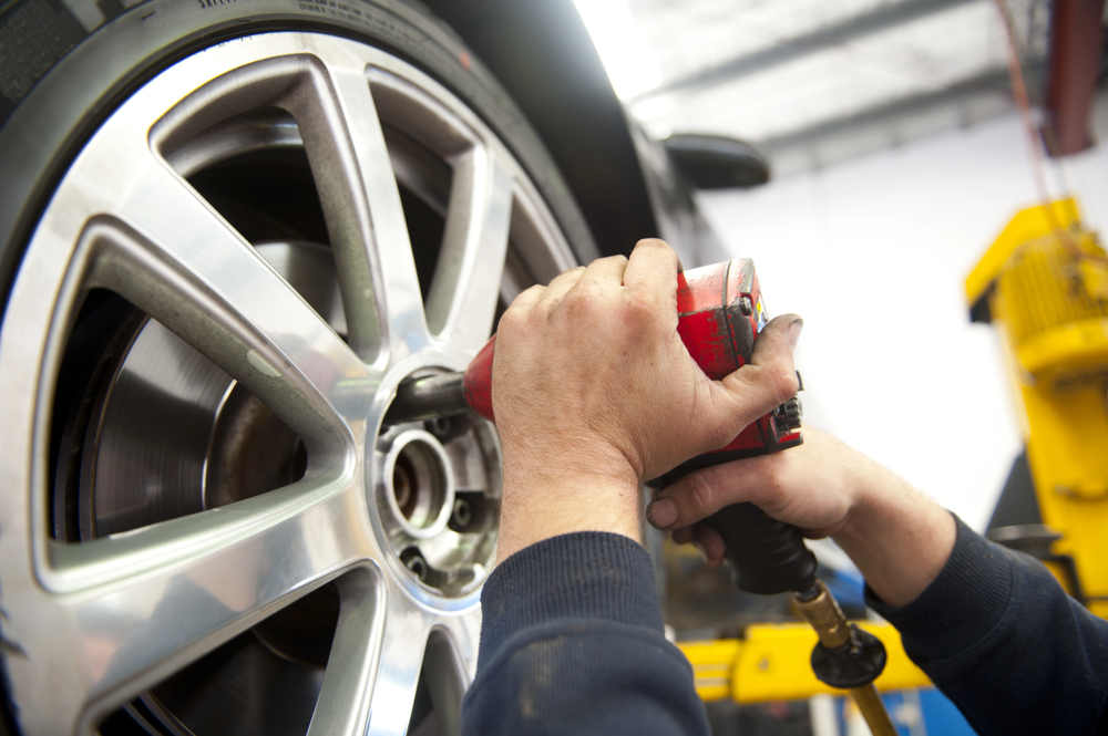 Mechaniker wechselt einen Autoreifen in der Werkstatt