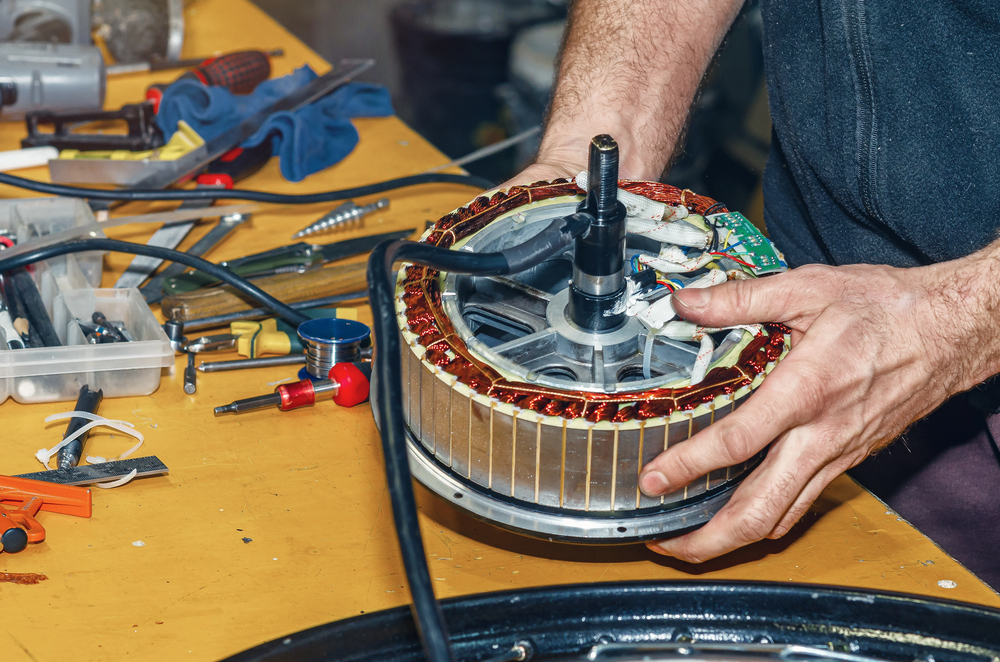 Mechaniker überprüft ein eBike in der Werkstatt auf einer Montagestütze